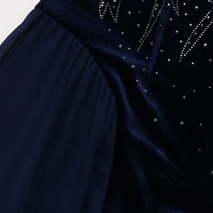 Detail of navy blue velvet dress featuring elegant rhinestone patterns and chiffon mesh