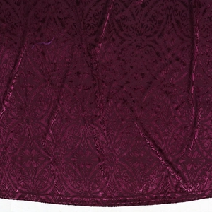 Detailansicht der Samt-Damast-Struktur und Saumnaht am burgunderroten Abendkleid