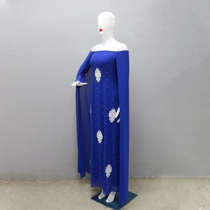 Détail d'une robe en mousseline bleu roi avec fleurs en dentelle blanche et perles