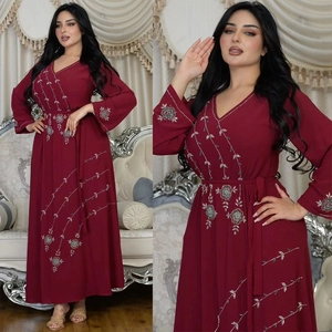 Detail of wine red Abaya dress showing floral embroidery, sequins and V-neckline texture