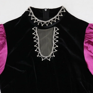 Close-up of velvet gown featuring rhinestone heart collar and purple puff sleeves
