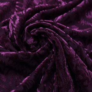 Detail von dunkelviolettem Samtstoff mit floralem Ausbrenner-Muster und feiner Textur