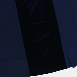 Detailed macro view of navy blue velvet patchwork stitching and dual-needle hem finish