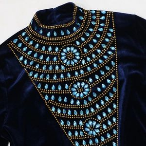Detail of teal crystal teardrop and gold bead embroidery on dark blue velvet gown