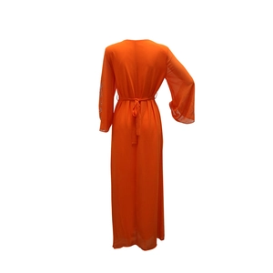 Détail d'une robe maxi en mousseline orange avec manches évasées et sequins argentés
