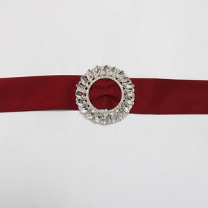 Detail of burgundy satin belt with a sparkling round rhinestone buckle for evening gowns