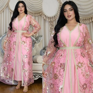 Détail de broderies florales à paillettes roses sur une robe caftan en maille filet