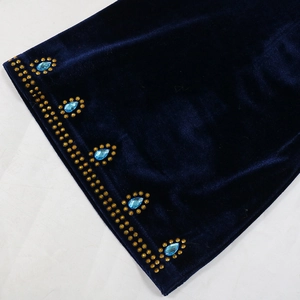 Detail of blue velvet fabric with water-drop crystals and golden rhinestones