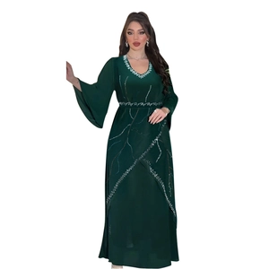 Detail of green chiffon robe featuring intricate white beadwork and rhinestone patterns