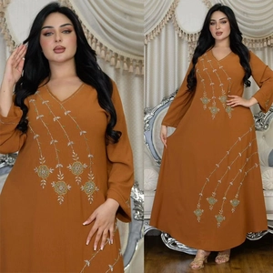 Detail view of amber maxi dress featuring intricate green and gold floral embroidery and beads