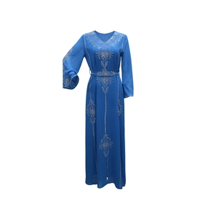 Détails de strass argentés sur l'encolure et le devant d'une robe caftan bleu foncé