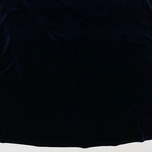 Detail of dark blue velvet fabric featuring subtle light reflection and soft texture