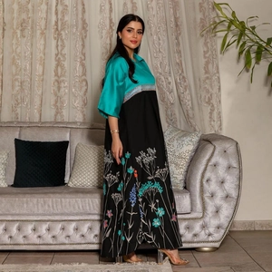 Women's teal satin patchwork dress with colorful floral embroidery and large black hem
