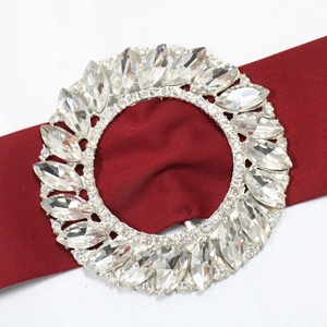 Detail of a silver rhinestone buckle with marquise cut crystals on red fabric