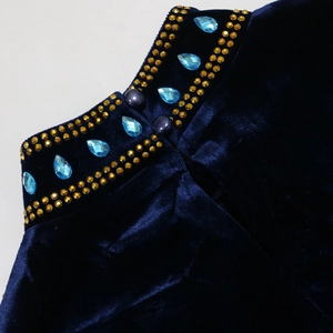Macro detail of navy velvet neckline featuring gold rhinestones and light blue teardrop gems