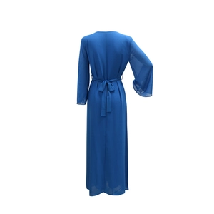 Détail de la robe en mousseline bleu roi avec ceinture nouée et poignets à paillettes