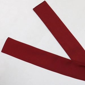Detailed close-up of the wine red fabric belt with neat stitching for evening dress