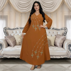 Detailed close-up of intricate floral embroidery and sequins on long orange abaya dress