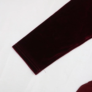 Detailed close-up of dark burgundy velvet sleeve cuffs with refined stitching detail