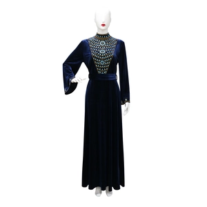 Detail of blue velvet long dress featuring intricate gold and blue rhinestone patterns