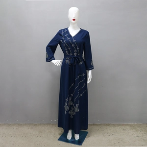 Detail of navy blue Abaya dress featuring white sequin floral embroidery and V-neckline