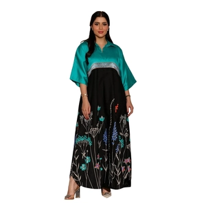 Detail view of long printed dress featuring turquoise V-neck bodice and floral skirt