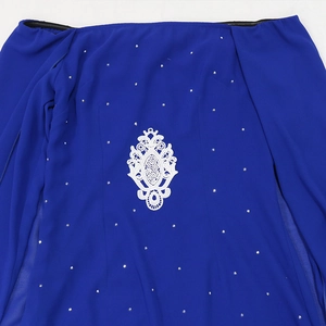 Détail d'une robe en mousseline bleu marine avec fleurs en dentelle et strass argentés