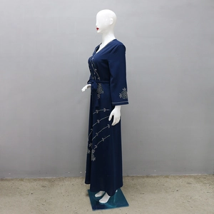 Detailed close-up of silver rhinestone floral embroidery on a navy blue kaftan maxi dress