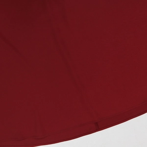 Detailed close-up of double-needle hem stitching on burgundy evening dress fabric
