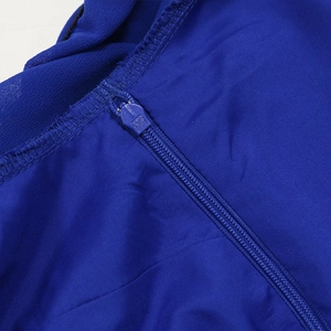 Détail macro d'une robe en mousseline bleu roi montrant la fermeture éclair et les coutures