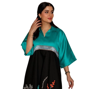 Close-up of turquoise and black satin robe dress featuring intricate sequin embroidery
