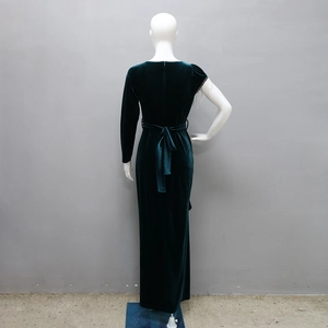 Detail view of dark green velvet evening gown featuring elegant silver fringe and waist belt