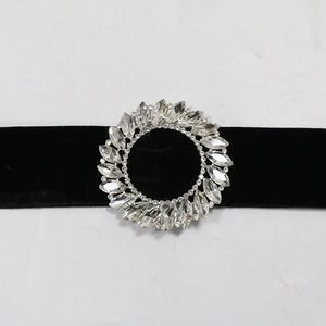 Close-up of black velvet choker featuring a large circular rhinestone buckle detail