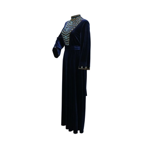 Close-up of velvet gown featuring intricate turquoise rhinestones and golden beadwork