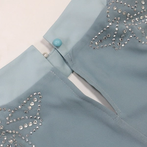 Detailed view of light blue chiffon dress with radiant rhinestones and button closure
