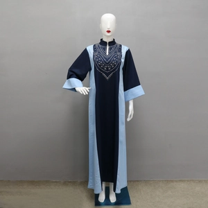 Détail d'une robe abaya patchwork bleu marine et bleu clair avec motifs en strass