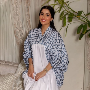 Details der Fledermausärmel und des blauen Druckmusters auf diesem weißen Kaftan