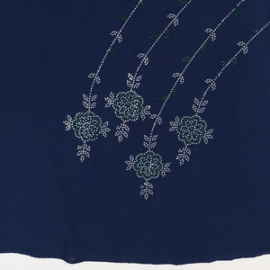 Close-up of sparkling floral rhinestones on deep blue fabric dress detail