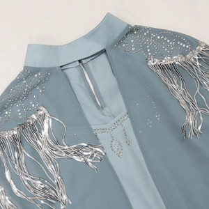 Detail of sequins and silver fringe on a light blue dress with rhinestone embellishments