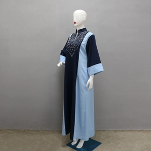 Détail des ornements en strass argentés sur une robe longue à empiècements bleus contrastés