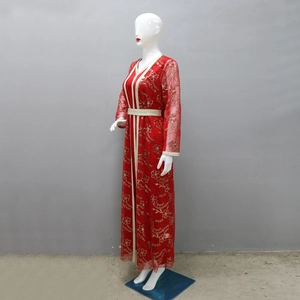 Détails de broderie sur un caftan marocain rouge avec sequins dorés et rubans tissés