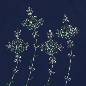Detailed view of green and silver rhinestones in flower patterns on navy blue fabric