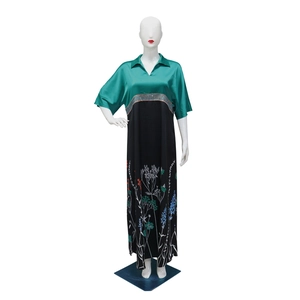 Detail of long-sleeved dress with dark green satin top and floral print skirt