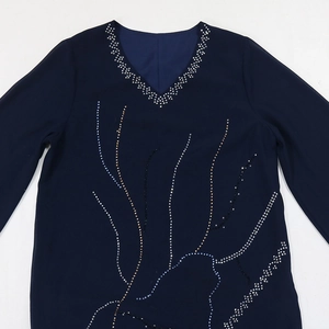 Close-up of V-neckline with silver rhinestones and intricate beadwork on navy chiffon