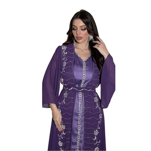 Dettaglio dell'abito in chiffon viola con ricami floreali argentati e strass scintillanti