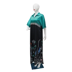 Detailed close-up of emerald green silk lapel and silver blue sequin belt on the dress