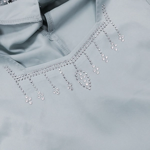 Detail of light blue dress showing intricate sequin fringe and rhinestone embroidery work