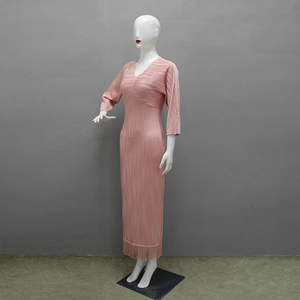 Dettaglio dell'abito in maglia a pieghe rosa con frange eleganti e scollo a V