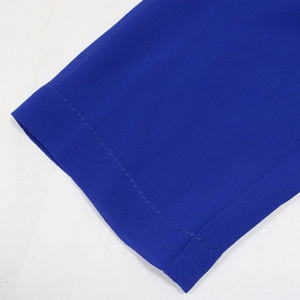 Détail de la manche d'une robe en mousseline bleu roi avec coutures précises et texture