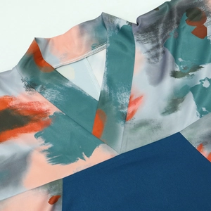 Detail eines V-Ausschnitts einer bunten Robe mit Aquarelldruck und Seidentextur